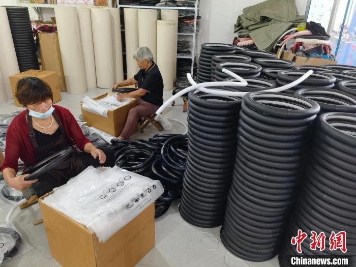 圖為村民在汽車飾品企業(yè)生產(chǎn)車間中工作。　呂子豪 攝