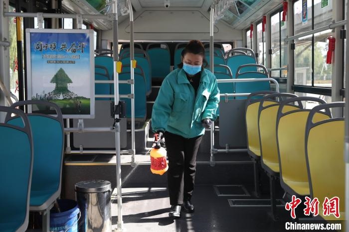 工作人員正在對(duì)公交車進(jìn)行消殺?！∮诰?攝