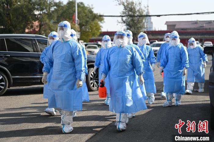 圖為醫(yī)務人員在封閉小區(qū)做防控工作?！⑽娜A 攝