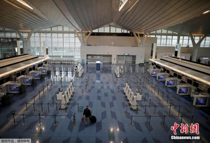 資料圖：日本東京，東京國際機場，一名乘客在國際航班航站樓的登機區(qū)。