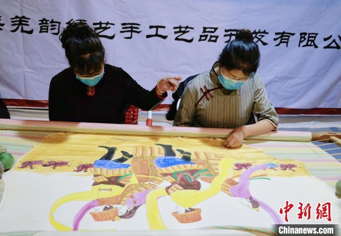 圖為皮繡藝人在市集上“秀”指尖技藝?！●R銘言 攝