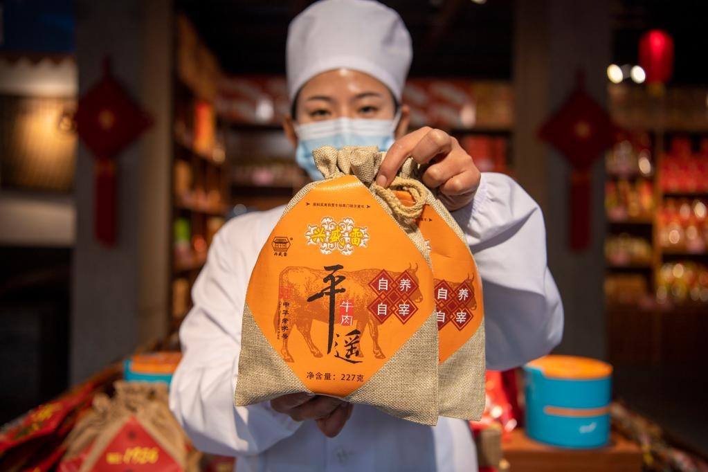 1月27日，在平遙古城南大街的一家平遙牛肉店內(nèi)，工作人員展示一款牛肉產(chǎn)品。新華社記者 楊晨光 攝