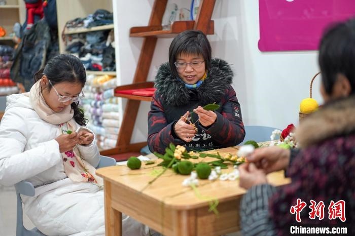 文創(chuàng)工作室的姐妹們正在鉤織月桂葉片。　古良駒 攝