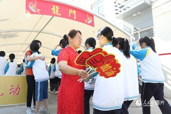 6月7日一早，雄安新區(qū)安新中學(xué)老師在給同學(xué)們加油鼓勁兒。人民網(wǎng) 李兆民攝