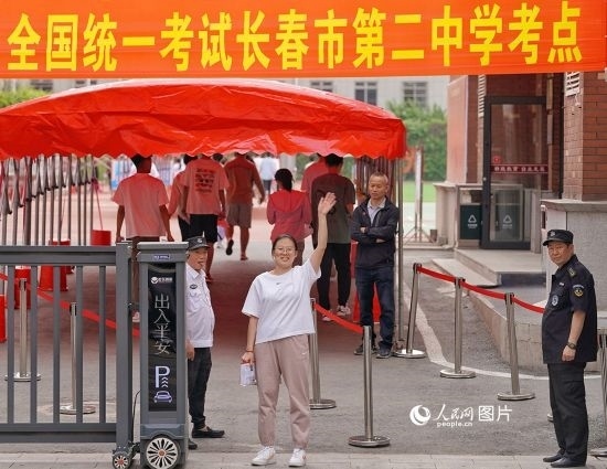 6月7日，在長(zhǎng)春市第二中學(xué)考點(diǎn)，一名考生信心滿滿進(jìn)入考場(chǎng)，并與家長(zhǎng)揮手致意。人民網(wǎng)記者 李洋攝
