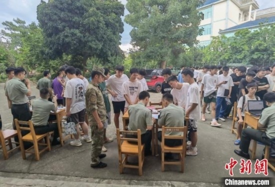 專武干部在發(fā)放兵役登記證。韋碩 攝