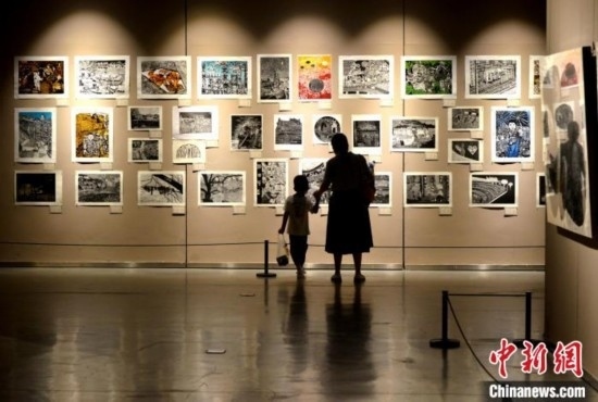 圖為家長帶著孩子參觀展覽。呂明 攝