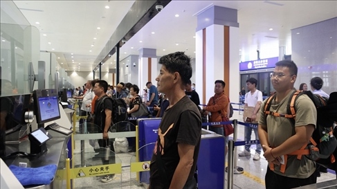 6月13日，乘坐中老鐵路國際旅客列車的旅客在磨憨邊檢大廳排隊候檢。李揚 攝