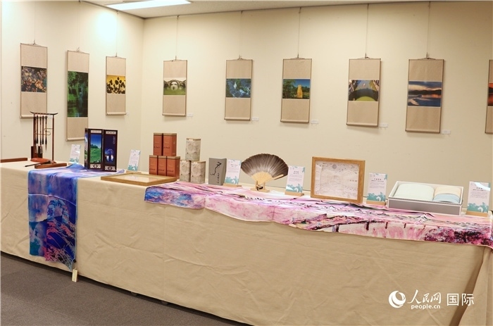 現(xiàn)場展出的馮學敏攝影作品與湖州市特色工藝品。（人民網(wǎng) 許可攝）