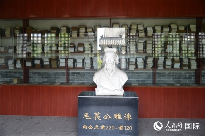 河間詩(shī)經(jīng)齋毛萇雕像。雕像后書(shū)櫥中陳列的是歷代各版本《詩(shī)經(jīng)》及譯本。 人民網(wǎng) 趙昭攝