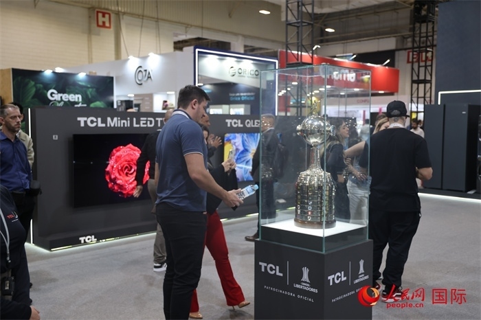 參觀者在TCL展臺前觀看南美解放者杯獎杯，據(jù)介紹，TCL是南美解放者杯（2023—2026賽季）全球官方合作伙伴。（人民網(wǎng)記者 時元皓攝）