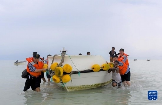 7月21日，中國海軍“和平方舟”號(hào)醫(yī)院船醫(yī)護(hù)人員涉水登島，前往基里巴斯一診療點(diǎn)。新華社記者 黎云 攝