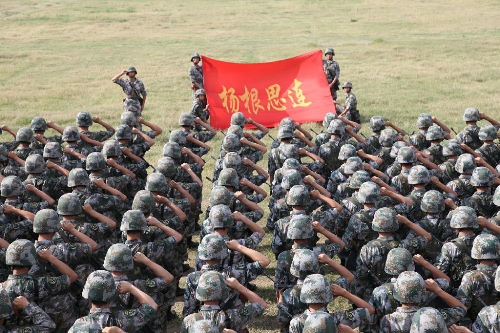 ↑“楊根思連”官兵執(zhí)行任務(wù)前向連旗宣誓（資料照片）。新華社發(fā)