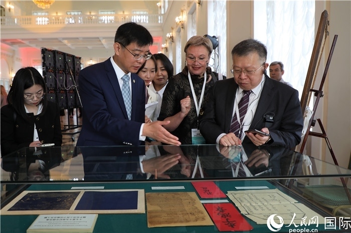 中俄圖書館論壇嘉賓共同參觀由俄羅斯國立列寧圖書館舉辦的館藏中國古籍善本圖書展。人民網記者 隋鑫攝）