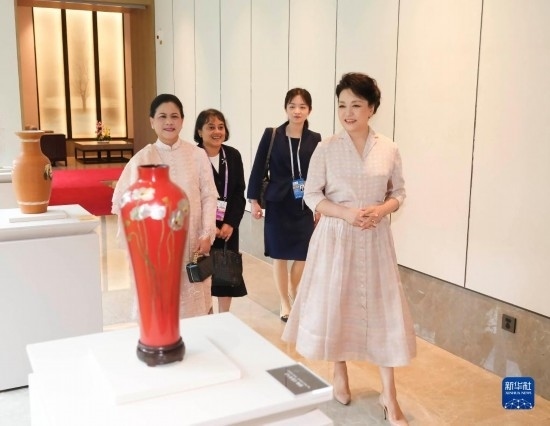 7月27日下午，國(guó)家主席習(xí)近平夫人彭麗媛在四川成都會(huì)見(jiàn)陪同印度尼西亞總統(tǒng)佐科來(lái)華出席第31屆世界大學(xué)生夏季運(yùn)動(dòng)會(huì)開(kāi)幕式并訪華的總統(tǒng)夫人伊莉亞娜。這是彭麗媛和伊莉亞娜欣賞成都特色非遺工藝品。新華社記者 丁林 攝