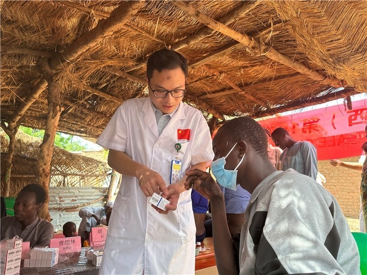 圖為南昌大學第一附屬醫(yī)院病理科主治醫(yī)師張振東為村民解說藥品使用方法。中國駐乍得醫(yī)療隊供圖