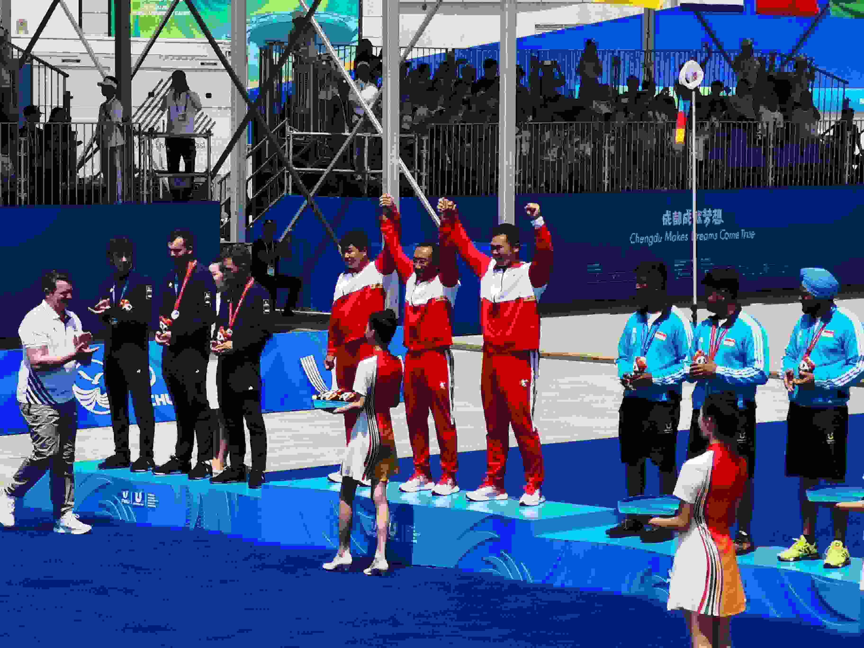 7月30日，在成都大運會男子復(fù)合弓團體頒獎儀式中，中國隊慶祝奪得冠軍。 人民網(wǎng)記者 楊磊攝