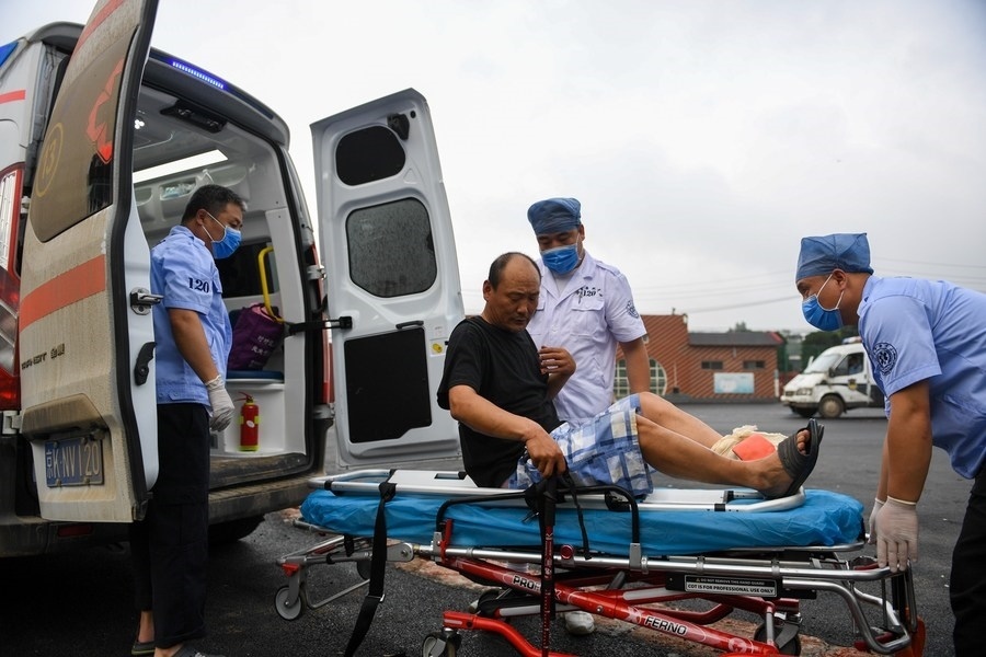 8月1日，在北京市門頭溝區(qū)妙峰山鎮(zhèn)妙峰山民族學(xué)校臨時(shí)安置點(diǎn)，北京急救中心工作人員在轉(zhuǎn)運(yùn)一名受傷村民。新華社記者 鞠煥宗 攝
