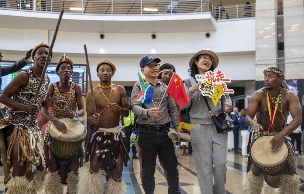 在南非約翰內(nèi)斯堡坦博國際機場，南非舞蹈演員歡迎中國試點恢復(fù)出境團隊旅游后首批抵達南非的中國游客（2023年3月29日攝）。