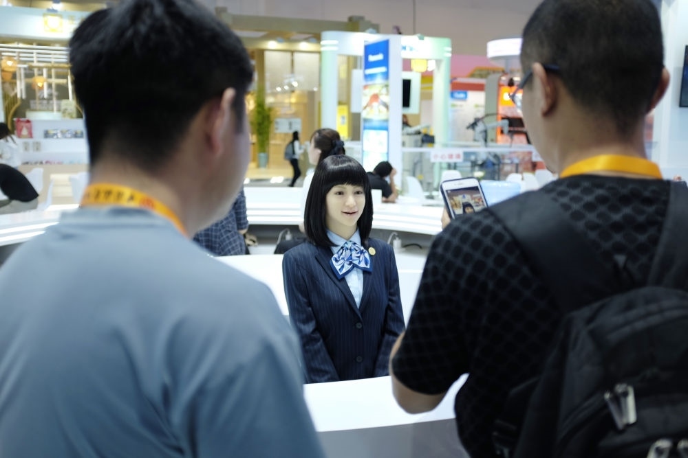 9月1日，媒體記者在國家會議中心與服務(wù)機(jī)器人互動。新華社記者 劉夢琪 攝