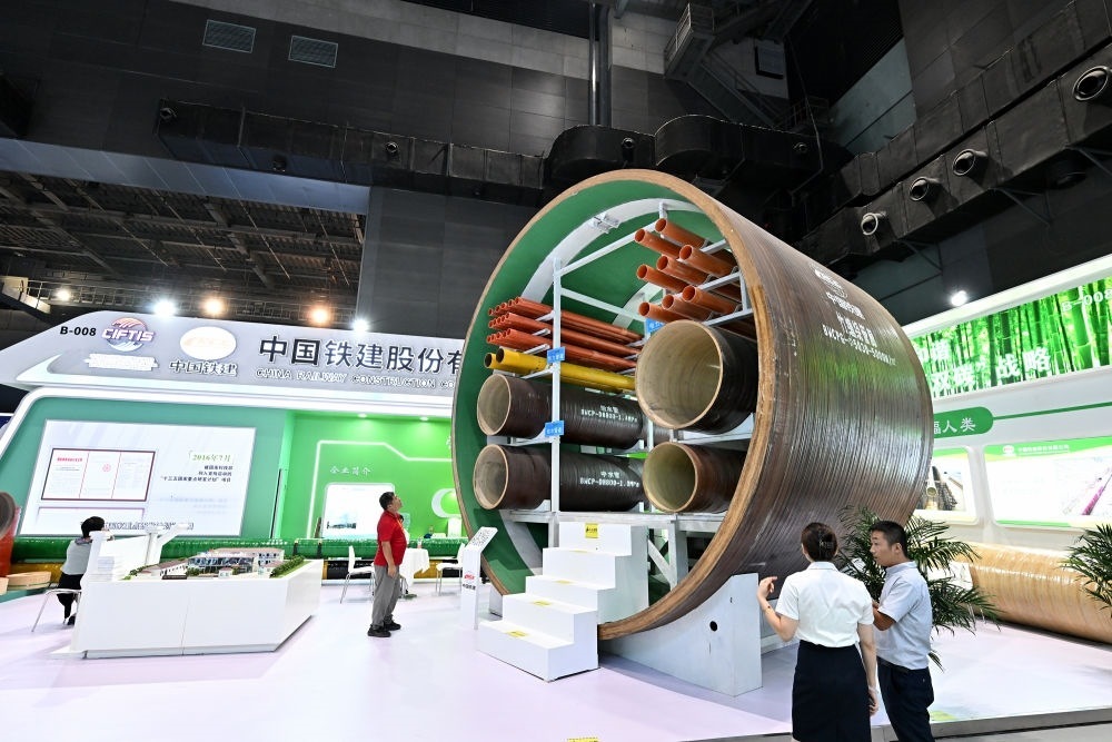 9月2日，在國家體育館舉行的服貿(mào)會(huì)環(huán)境服務(wù)專題展上，客商在中國鐵建展位竹纏繞管廊旁了解信息。新華社記者 李鑫 攝