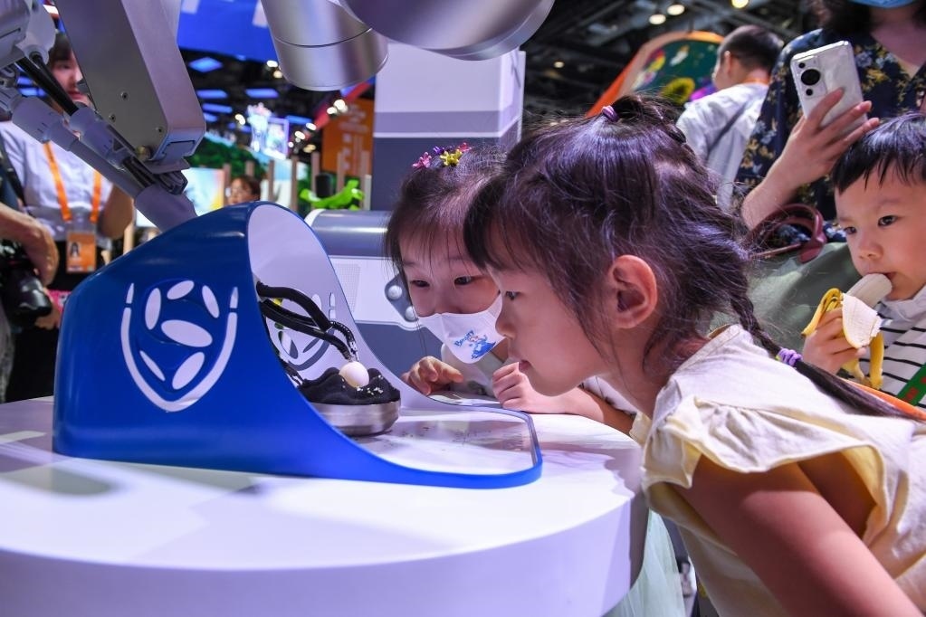 9月3日，幾名小朋友在國家會議中心觀看單孔腔鏡手術(shù)機(jī)器人展示。新華社記者 鞠煥宗 攝
