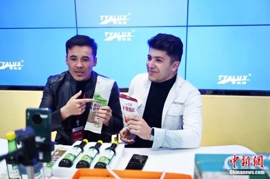 2023年3月，甘肅省慶陽(yáng)市環(huán)縣電商創(chuàng)業(yè)孵化基地內(nèi)，來(lái)自蘭州文理學(xué)院的塔吉克斯坦留學(xué)生正在協(xié)助主播直播帶貨當(dāng)?shù)剞r(nóng)特產(chǎn)品。李亞龍 攝