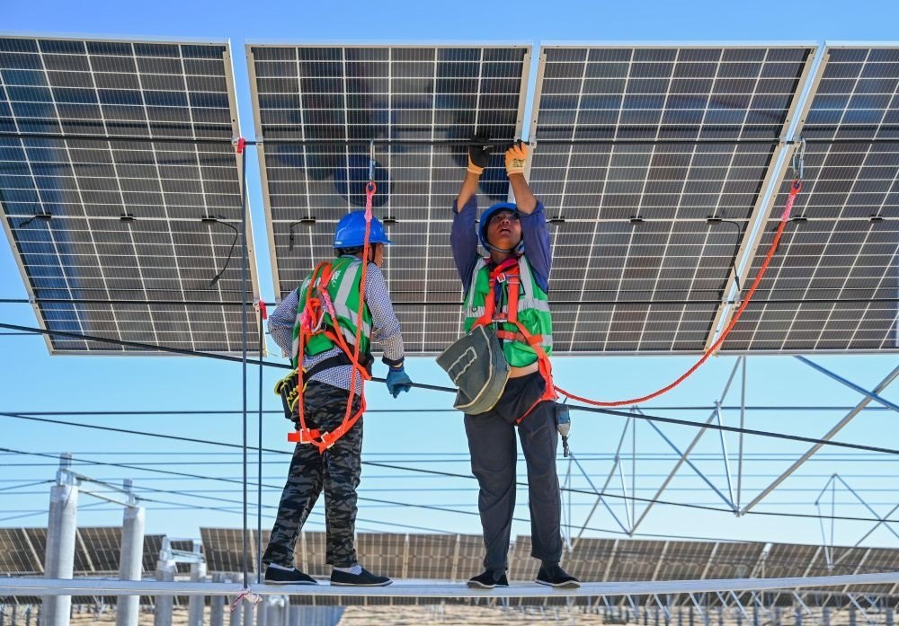 2023年7月22日，工人在位于內(nèi)蒙古杭錦旗庫布其沙漠億利生態(tài)示范區(qū)的蒙西基地庫布其200萬千瓦光伏治沙項目工地安裝光伏板。新華社記者 劉磊 攝