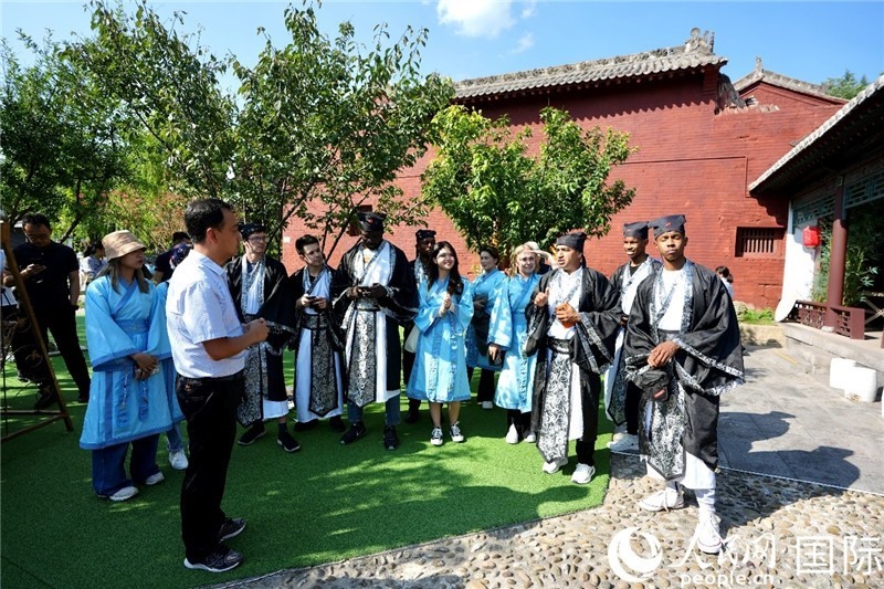 圖為選手們聽(tīng)導(dǎo)游講解。人民網(wǎng) 盧鵬宇攝