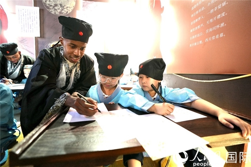 圖為選手與同學(xué)們一起寫書法。人民網(wǎng) 盧鵬宇攝