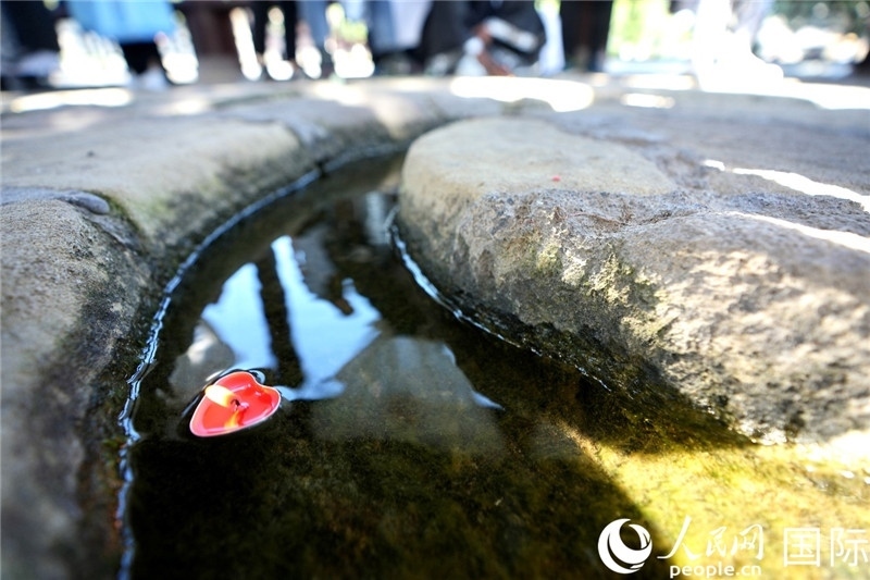 圖為水渠里流過(guò)的“桃心”蠟燭。人民網(wǎng) 盧鵬宇攝
