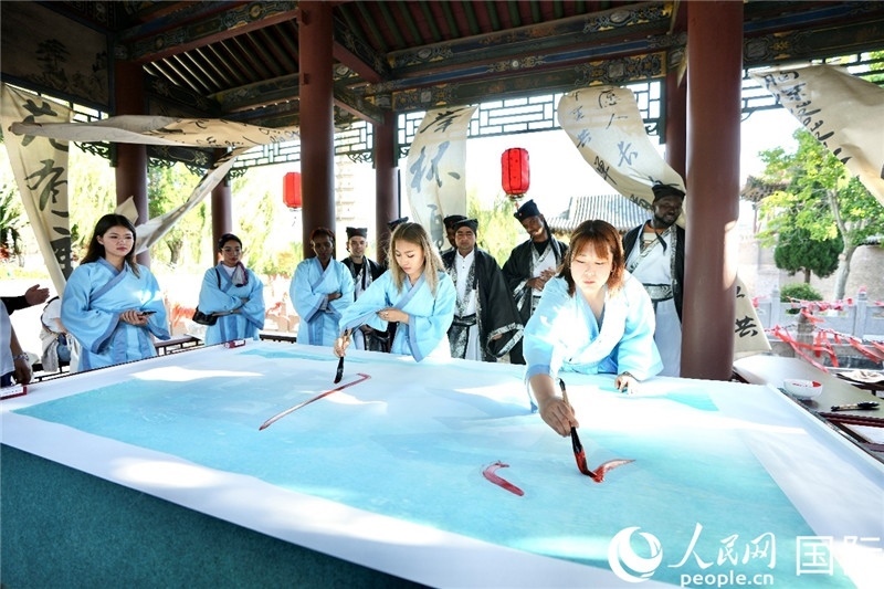 選手們提筆書寫“家園”二字。人民網(wǎng) 盧鵬宇攝