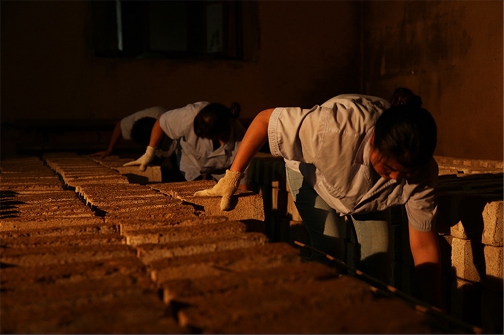 匠人師傅正在翻動曲胚。張?zhí)炝z