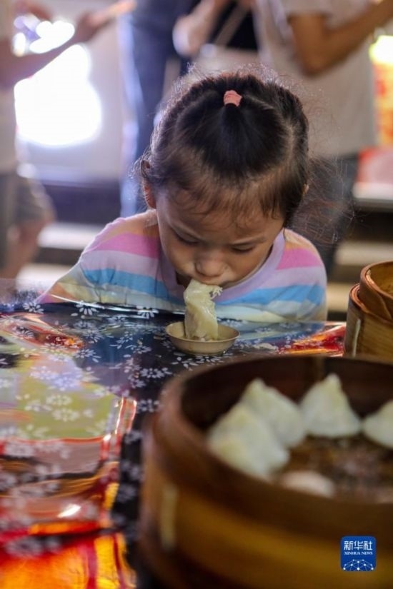 9月27日，小朋友在南翔小籠長街宴上品嘗南翔小籠。