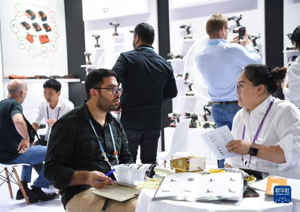 10月15日，在一家電動工具展臺，外國采購商在洽談業(yè)務(wù)。新華社記者 鄧華 攝