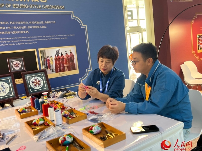 記者在新聞中心非遺傳承人展區(qū)進(jìn)行體驗(yàn)。人民網(wǎng)記者 杜燕飛攝