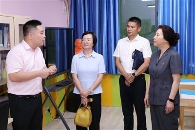 圖③：“小公民法律課堂”開講前，全國人大代表殷其龍（右二）、重慶市人大代表李自玲（左二）聽取楊家坪中學負責人關(guān)于未成年人思想教育工作情況的介紹。