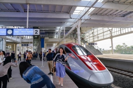  10月17日，在印度尼西亞萬隆德卡魯爾站，乘客在站臺上和雅萬高鐵高速動車組列車合影。新華社記者 徐欽 攝