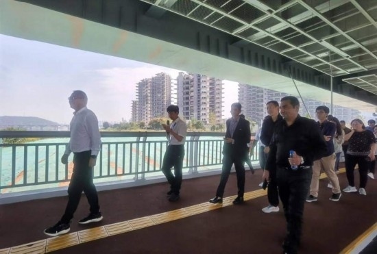 10月24日，2023“一帶一路”媒體合作論壇聯(lián)合采訪團(tuán)團(tuán)員走在清水塘大橋景觀通道上。本報(bào)記者 常雯宜攝