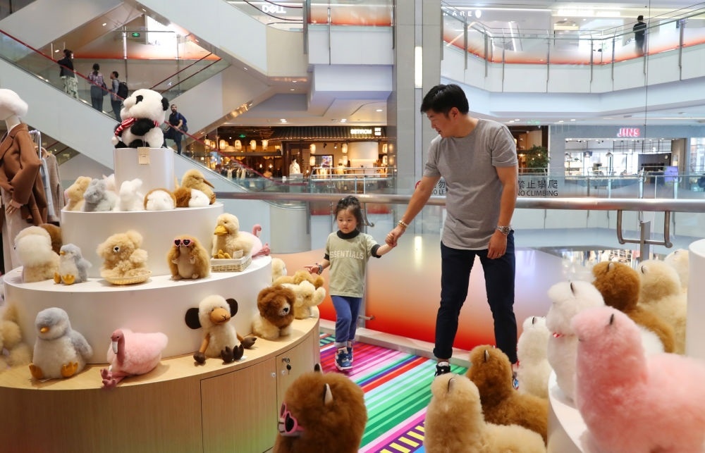 2023年11月2日，顧客在溫暖駝品牌專柜內(nèi)選購。連續(xù)六年參加進博會的秘魯羊駝制品品牌溫暖駝在上海市中心商場開設(shè)了專柜。新華社記者 方喆 攝