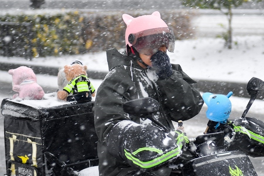 11月6日，在長春市街頭，一名外賣員在雪中騎行。新華社記者 許暢 攝