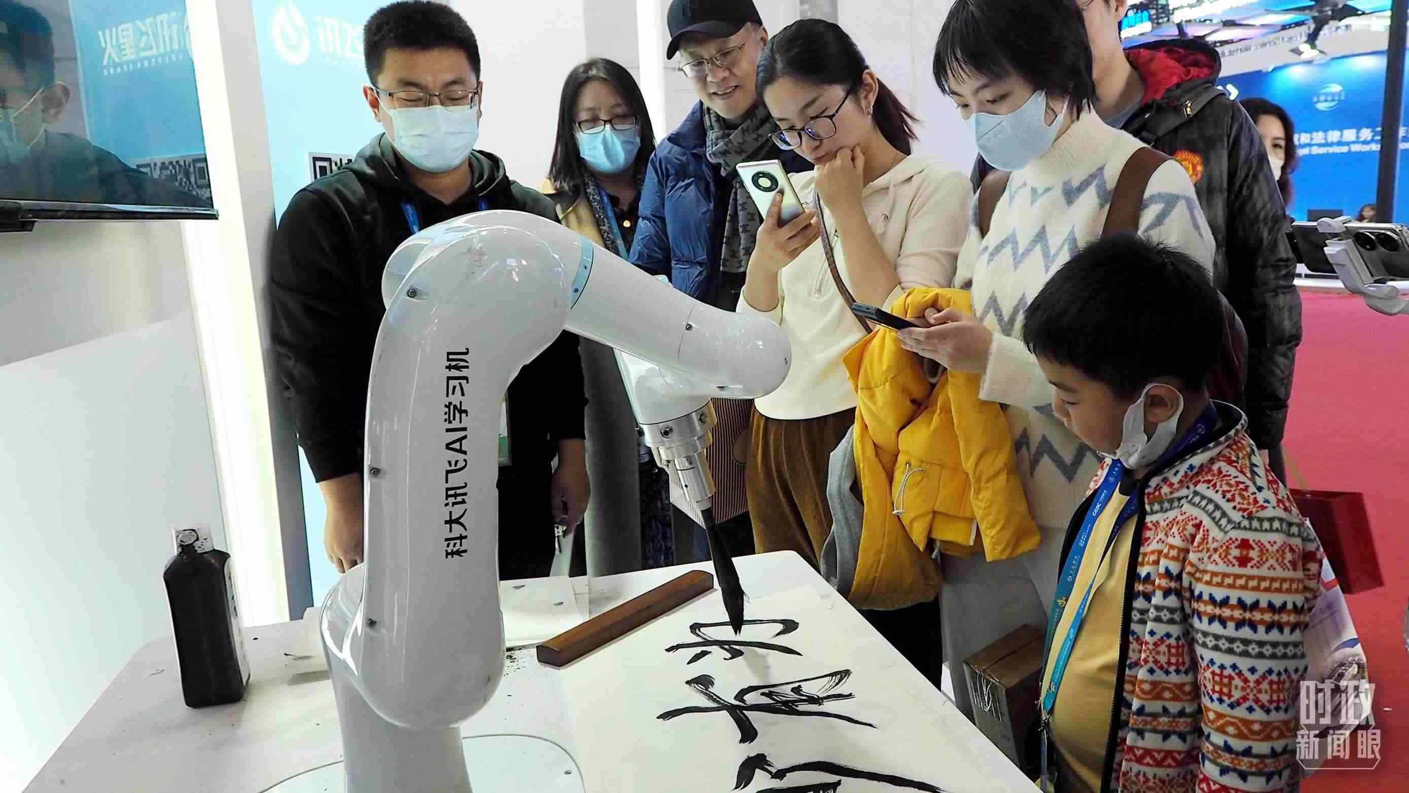 △觀眾在首屆鏈博會(huì)上體驗(yàn)AI書法機(jī)器人。