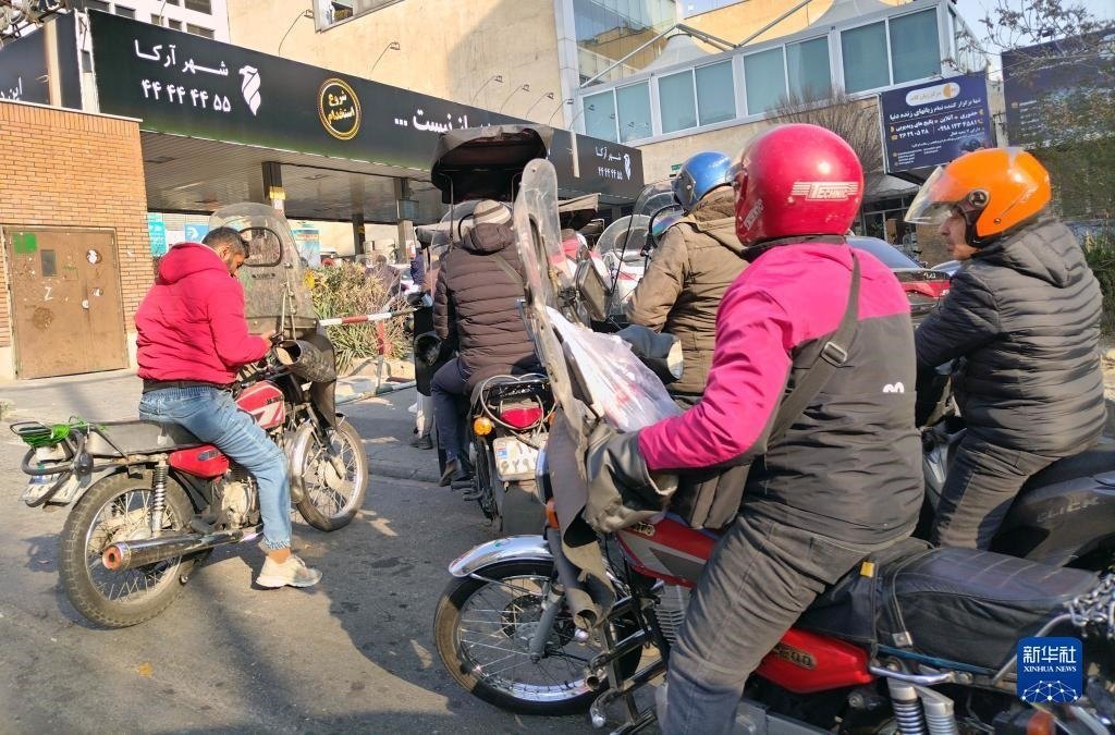 12月18日，摩托車在伊朗首都德黑蘭的一家加油站外等待加油。新華社記者 沙達(dá)提 攝