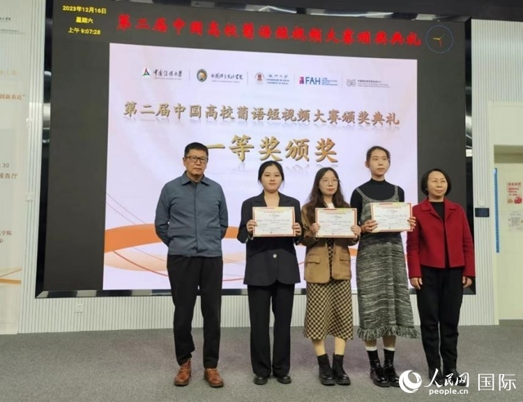 澳門大學(xué)中葡雙語教學(xué)暨培訓(xùn)中心主任姚京明（左一）和中國傳媒大學(xué)外國語言文化學(xué)院院長文春英（右一）為一等獎獲得者頒獎。人民網(wǎng)記者 魯揚(yáng)攝