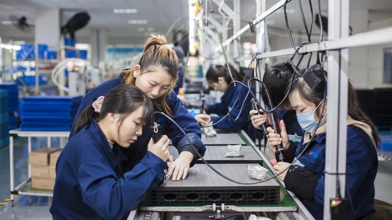 在新亞勝光電的產(chǎn)品線上，工人正進(jìn)行產(chǎn)品組建和安裝布線。受訪者供圖