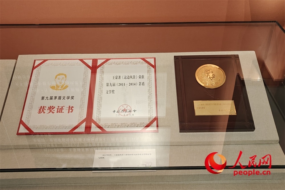 《這邊風景》獲得的第九屆茅盾文學獎證書與獎牌。人民網(wǎng)記者 韋衍行攝