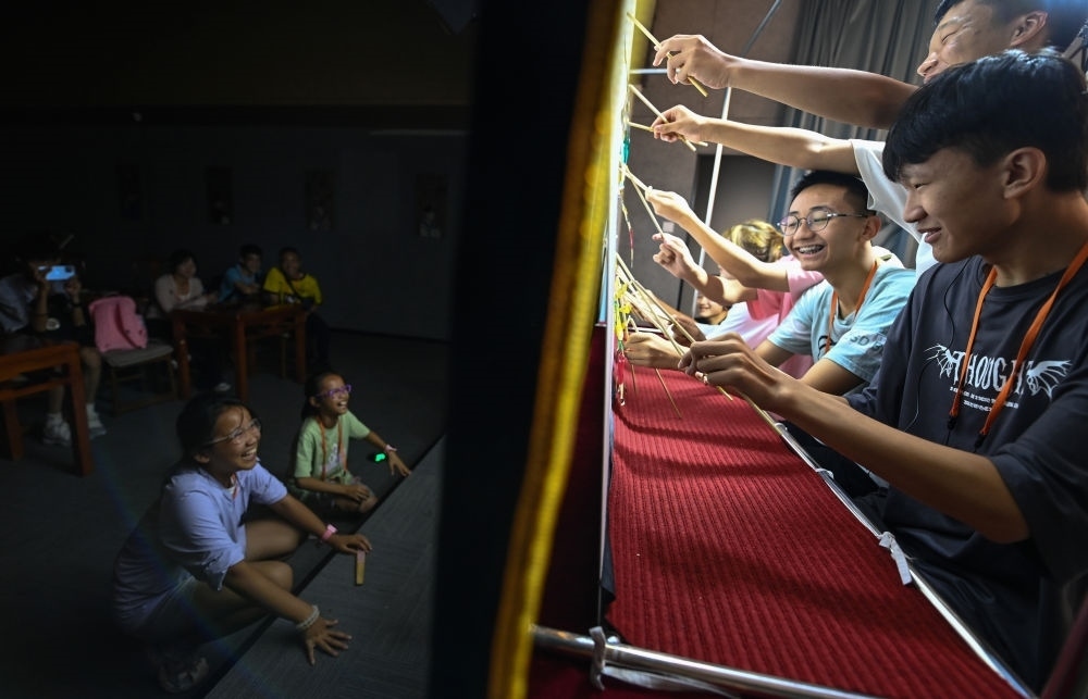 2023年8月8日，進(jìn)行暑期研學(xué)的學(xué)生在位于陜西省西安市的中國秦腔藝術(shù)博物館體驗皮影戲演出。新華社記者 鄒競一 攝