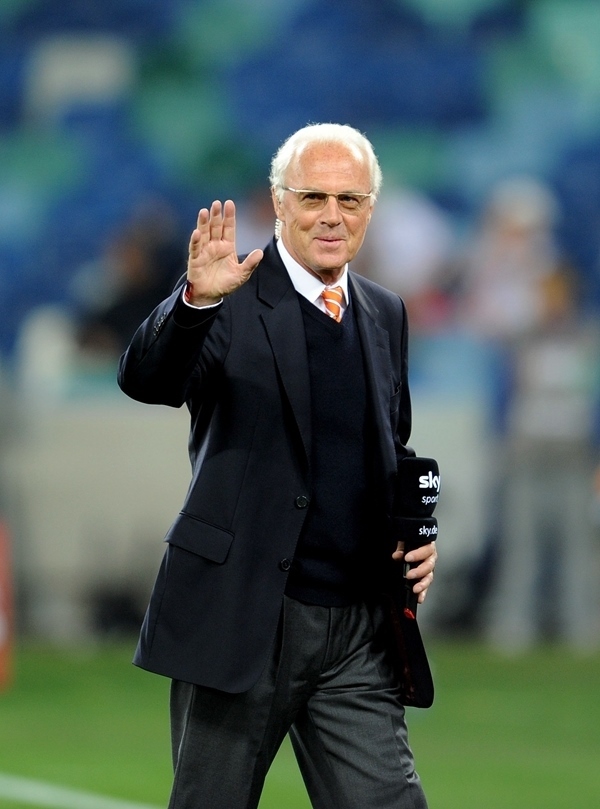 這是2010年7月7日，在南非德班舉行的2010年足球世界杯德國(guó)隊(duì)對(duì)陣西班牙隊(duì)的半決賽前，貝肯鮑爾接受電視臺(tái)采訪時(shí)和友人打招呼。新華社記者 王毓國(guó) 攝