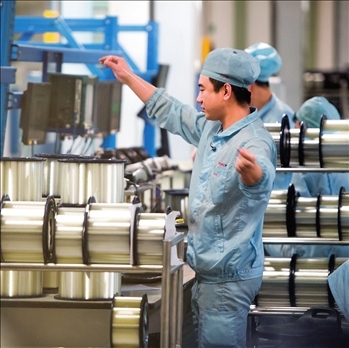 在位于武漢的長飛光纖光纜股份有限公司光纖生產(chǎn)車間內(nèi)，工作人員對光纖進行檢測（資料圖片）。肖藝九攝/本刊