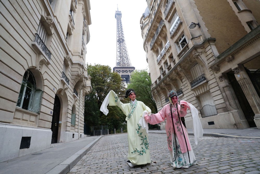 2023年9月13日，江蘇省演藝集團(tuán)昆劇院院長施夏明（左）和江蘇省演藝集團(tuán)昆劇院國家一級演員孔愛萍在法國巴黎埃菲爾鐵塔附近參加昆曲快閃。新華社記者 高靜 攝